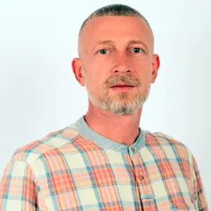 Porträtfoto Sebastian Stragies im karierten Hemd blickt neutral in die Kamera.