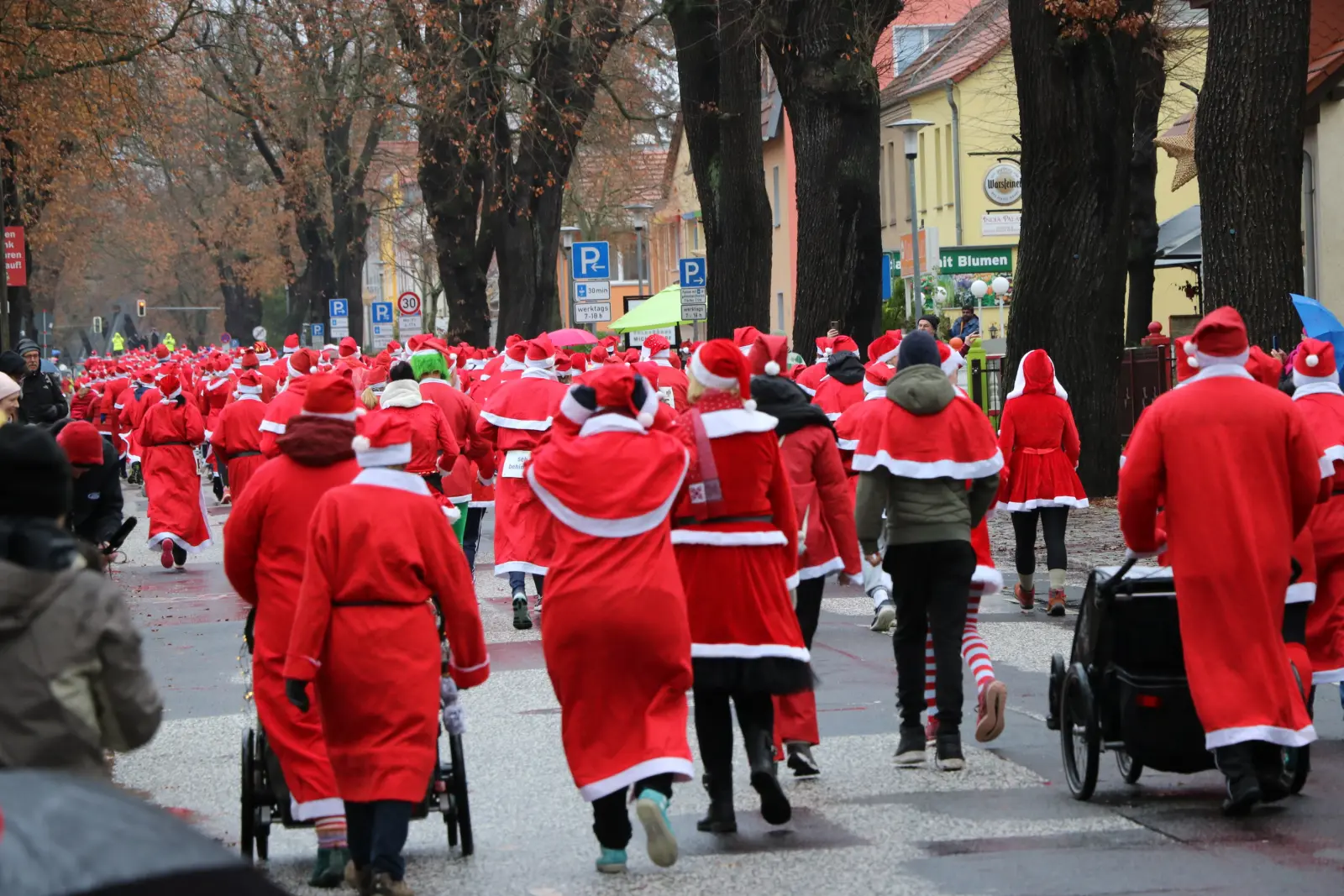 Viele Menschen in Nikolausmänteln und -mützen sind von hinten zu sehen