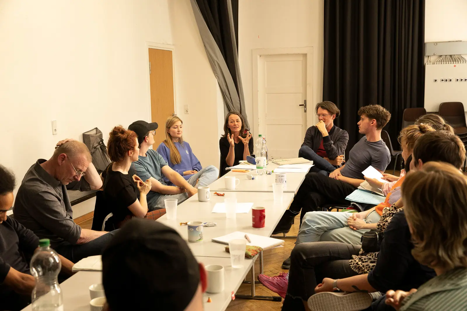 Workshop im GRIPS Theater Berlin: Theaterschaffende und Schreibende sitzen an einem Tisch und diskutieren.
