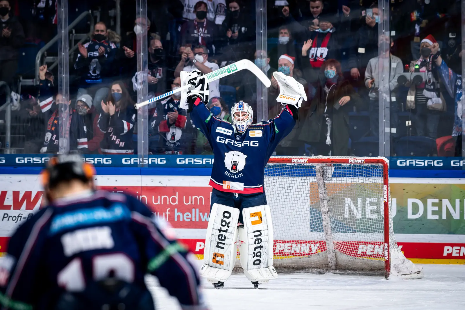 Torwart der Eisbären Berlin reckt den Eishockey-Schläger über den Kopf.
