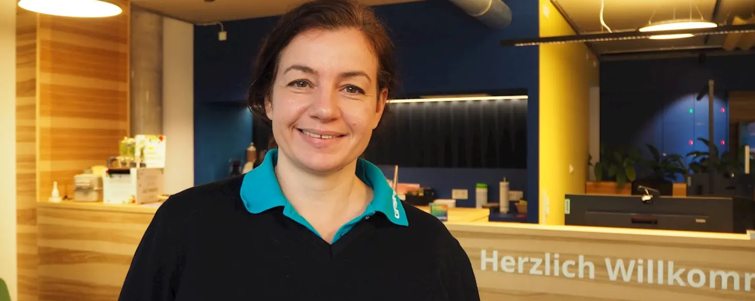 Dana Fritz steht im hell beleuchteten GASAG-Kundenzentrum und lächelt in die Kamera