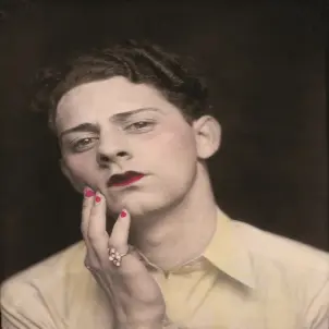 Ein Mann mit Make-Up trägt einen Damenring und hält die Hand an sein Gesicht. Bild datiert auf etwa 1920.