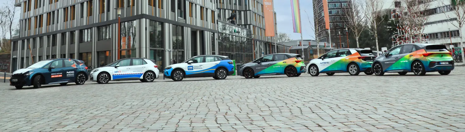 Sechs Elektroautos aus dem Fuhrpark der GASAG-Gruppe stehen im Halbkreis vor dem Hauptsitz des Unternehmens auf dem EUREF-Campus in Berlin.