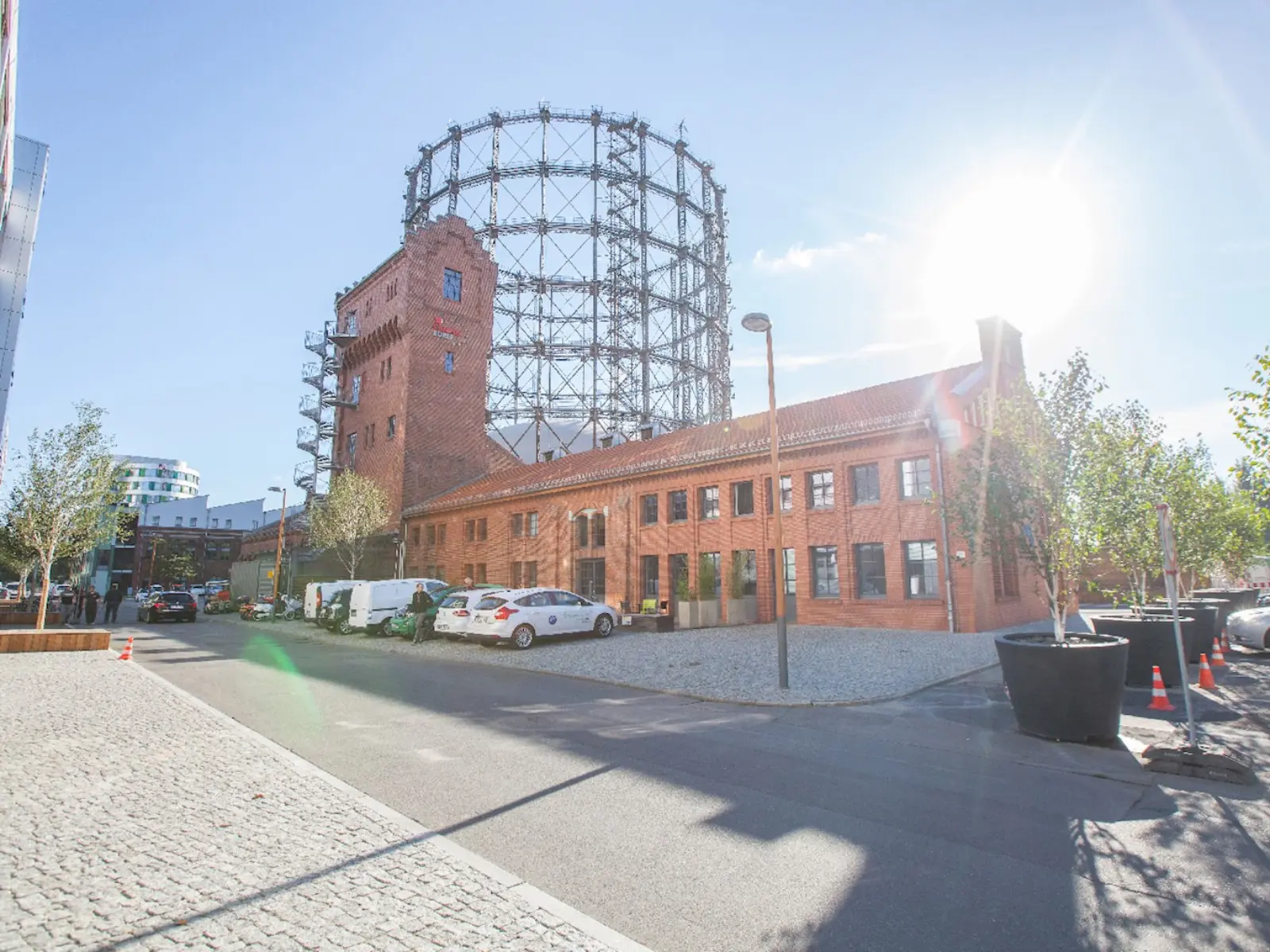 Im Vordergrund verläuft eine Straße, dahinter sind die RLCT-Energiewerkstatt und das Gasometer zu sehen