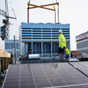Arbeiter installieren und prüfen eine Wärmepumpe auf dem Dach eines Hauses