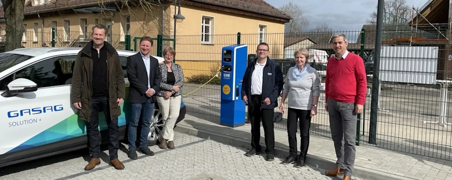 Sechs Personen stehen vor einer neuen EMB Ladesäule