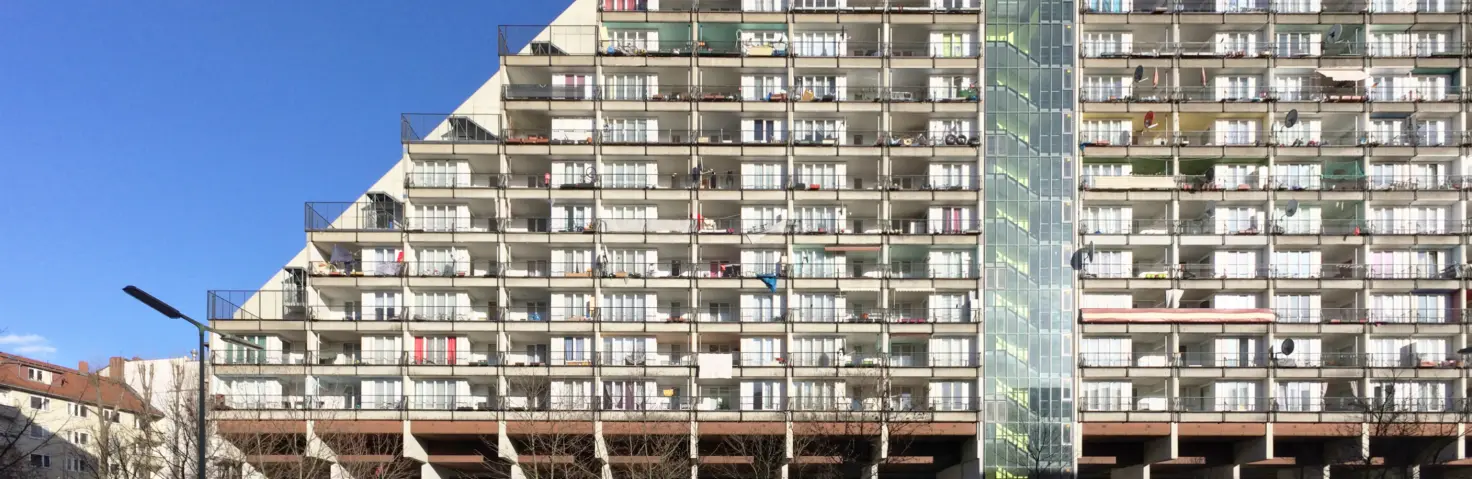 Wohngebäude Pallasseum in Berlin-Schöneberg mit markanter Terrassenform, durchgehenden Balkonen und zentralem Treppenhaus. Bild mit KI erstellt.