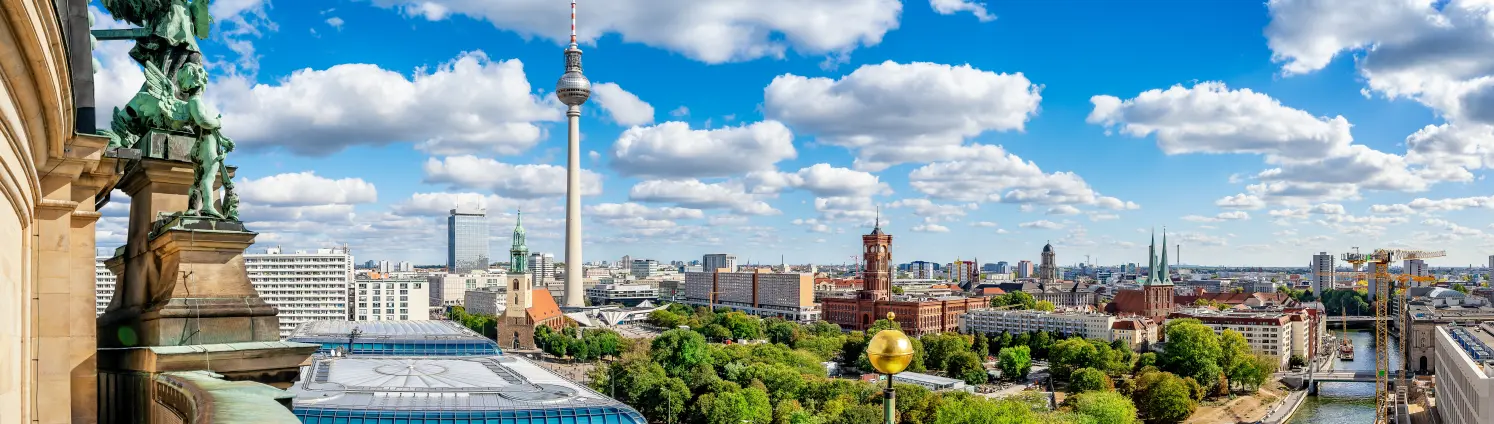 Blick von der Kuppel des Berliner Doms über die Skyline von Berlin-Mitte an einem sonnigen Tag mit blauem Himmel und weißen Wolken.