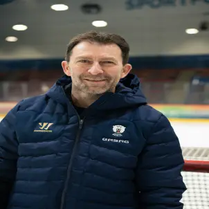 Porträtfoto: Sven Felski, Vorstandsvorsitzender der Eisbären Juniors Berlin, lacht und trägt eine dunkelblaue Daunenjacke mit Kapuze.