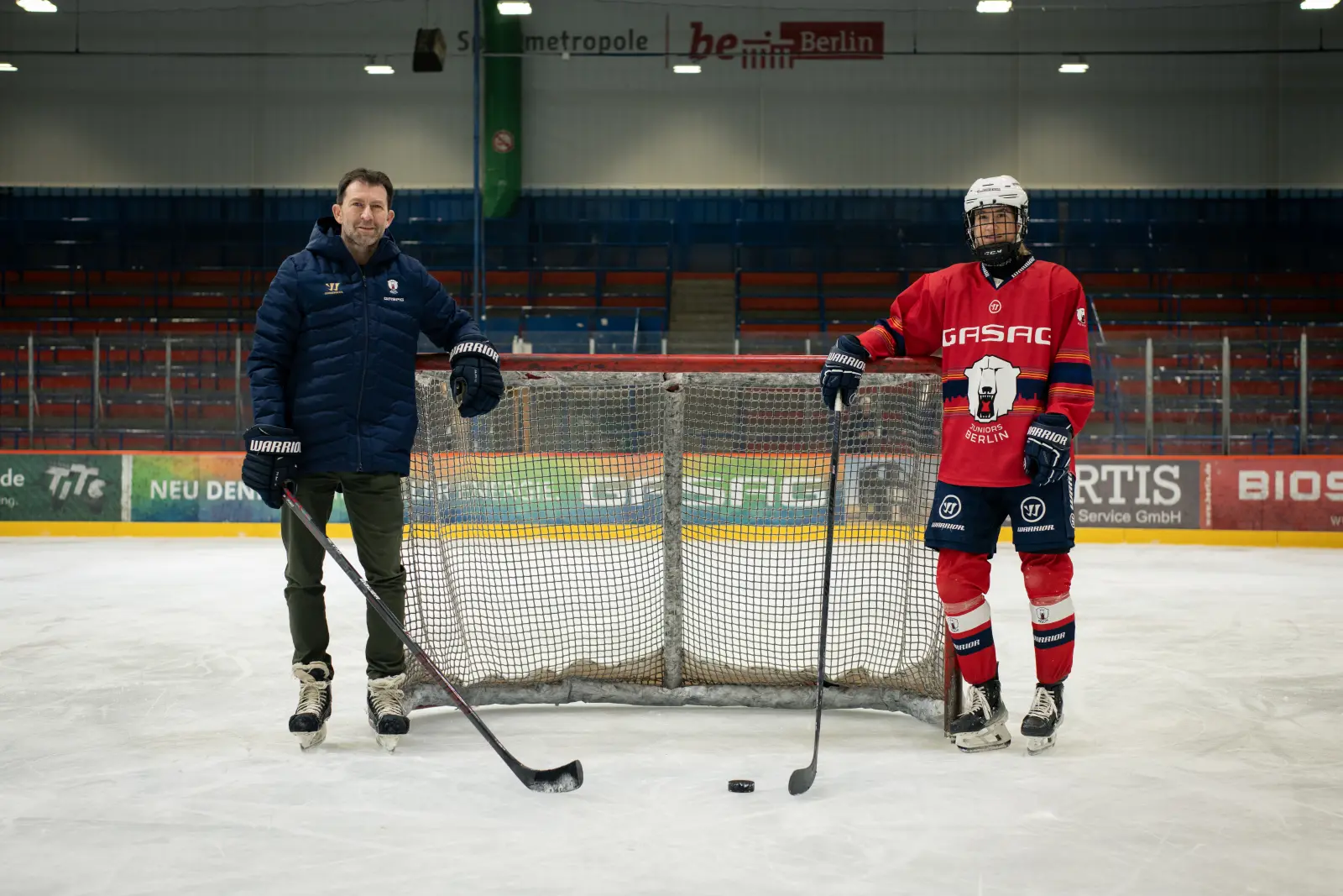 Sven Felski und Kai Wissmann von den Eisbären Berlin stehen mit Eishockey-Schlägern auf Schlittschuhen vor dem Tor.