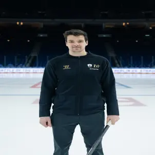 Kai Wissmann, Kapitän der Eisbären Berlin, trägt eine dunkelblaue Trainingsjacke und hält einen Eishockeyschläger in der Linken.